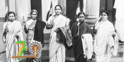Five women in saris holding flags on the steps of a colonnaded building.