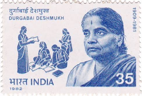 An Indian postage stamp printed in blue, showing Durgabai Deshmukh's portrait at the right and a drawing of a woman teaching seated women and children at the left. It reads Durgabai Deshmukh, 1909 to 1981, India, 1982, 35 paise.